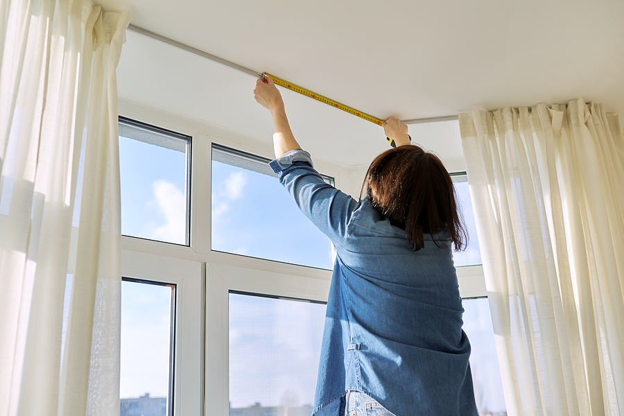 Woman installing curtains and blinds in Adelaide